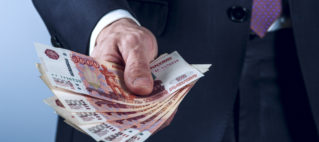 Man in a suit holds Russian rubles